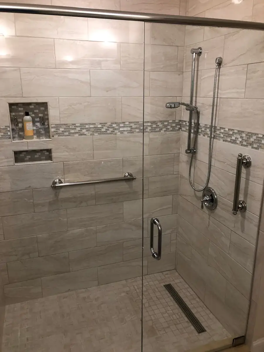 Large gray tiled shower with linear drain and multiple fixtures