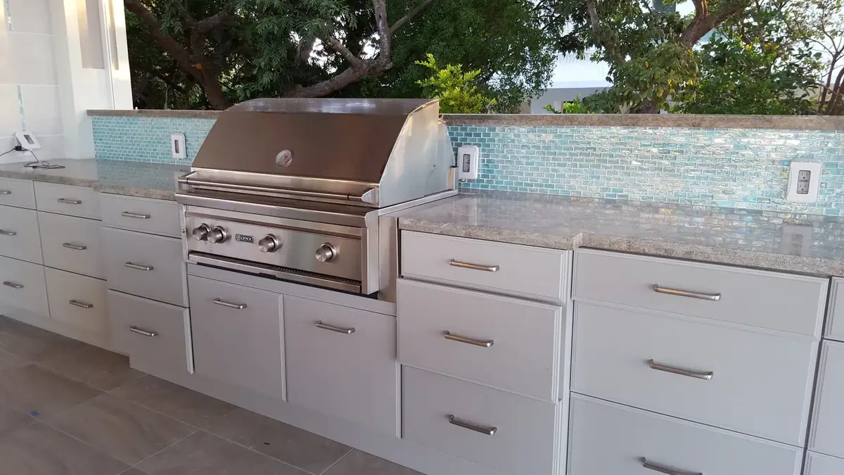 Outdoor kitchen with built-in grill, cabinets and mosaic backsplash